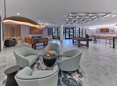 A modern club room with game tables, fire place, seating area