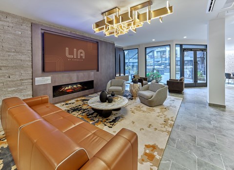 A modern club room with a fireplace and a large screen displaying the word