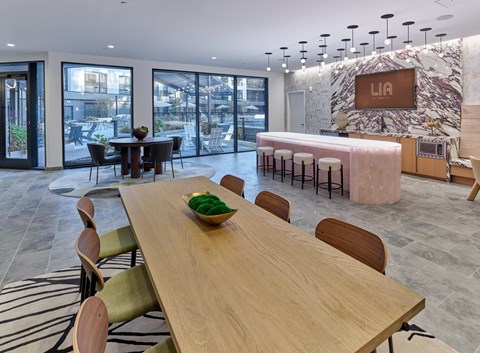 Club room with a long table and chairs, a bar area, and game tables.