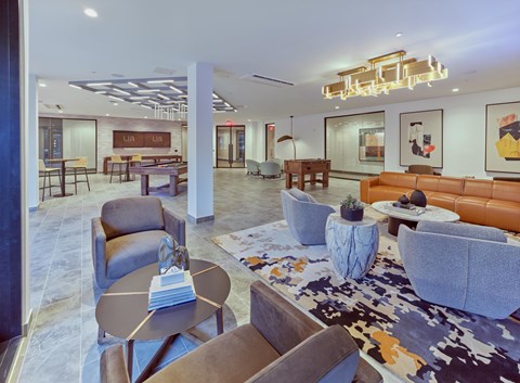 A modern living room with a variety of seating options and a large rug.