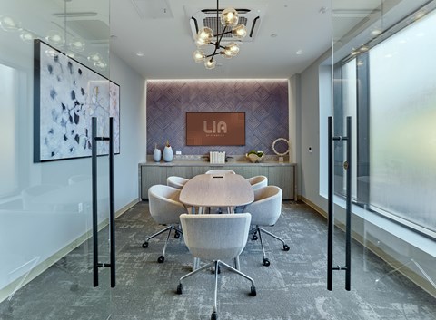 A conference room with a long table and chairs.
