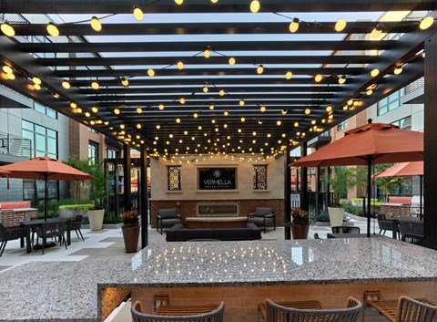 the lobby of a hotel with a bar and tables with umbrellas