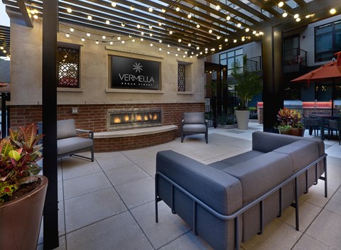 an outdoor patio with couches and a fireplace