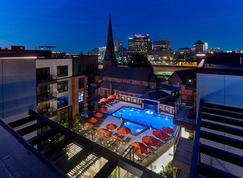 a hotel pool with a city in the background at night