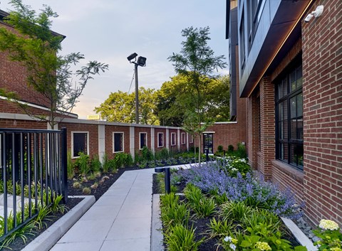 the courtyard of a building with plants and a sidewalk