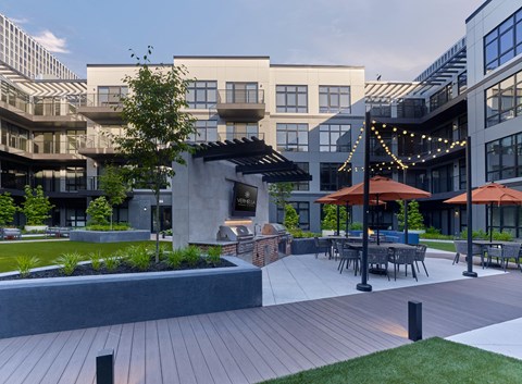 a courtyard with tables and umbrellas in front of a building