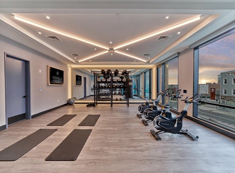 a gym with floor to ceiling windows and exercise equipment