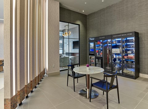 a lobby with a table and chairs next to a vending machine