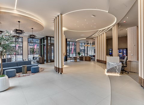 the lobby of a hotel with couches and a reception desk