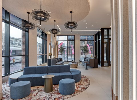 a lobby with blue couches and chairs and large windows