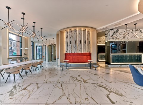 the lobby of a hotel with marble tables and a red couch