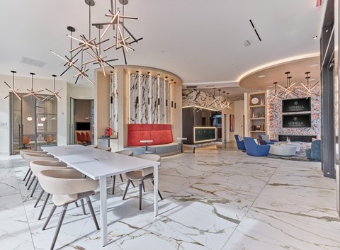 a dining room with tables and chairs and a living room with a fireplace