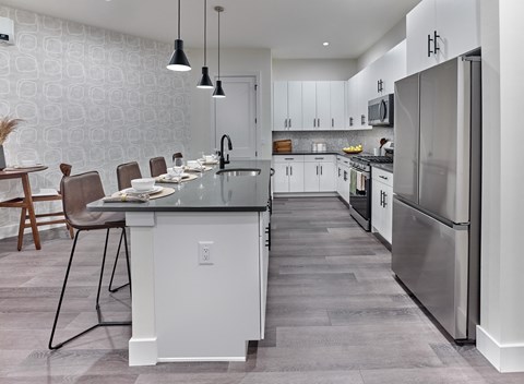 an open kitchen with a large island and stainless steel appliances