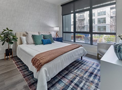 a bedroom with a bed and a large window