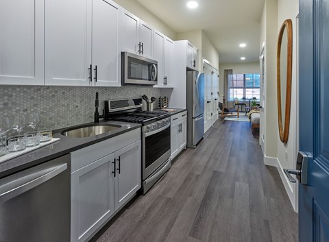 a kitchen with white cabinets and stainless steel appliances
