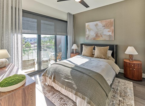 A bedroom with a large bed and a ceiling fan.
