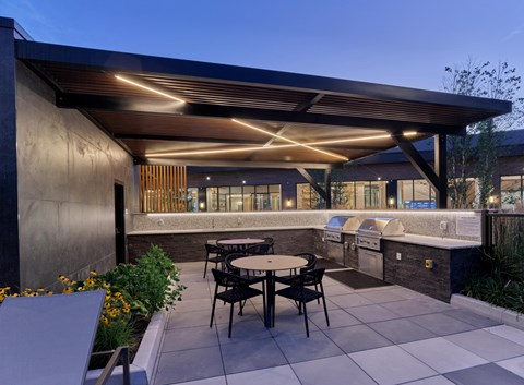 A patio with a table and chairs is lit up with lights.