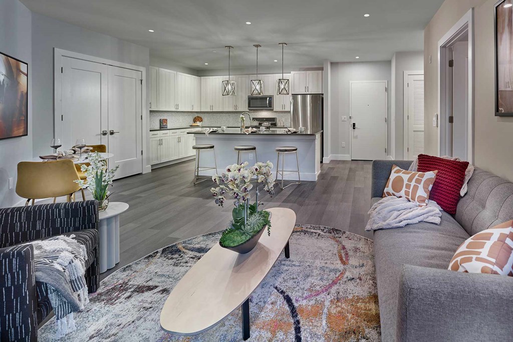 A modern living room with a grey sofa and a wooden coffee table.