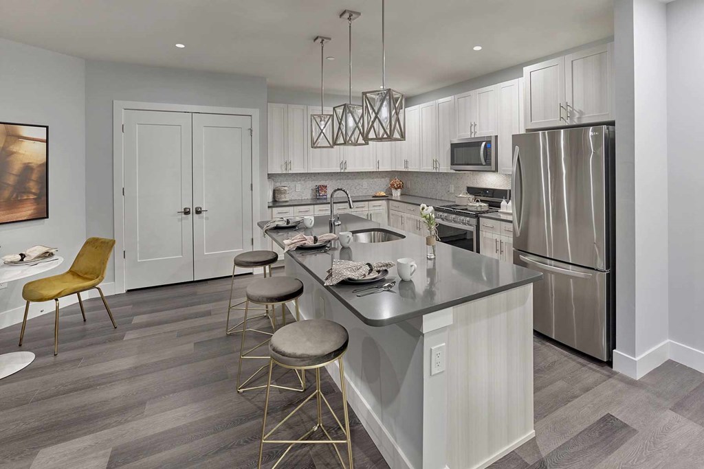 A modern kitchen with a large island and stainless steel appliances.