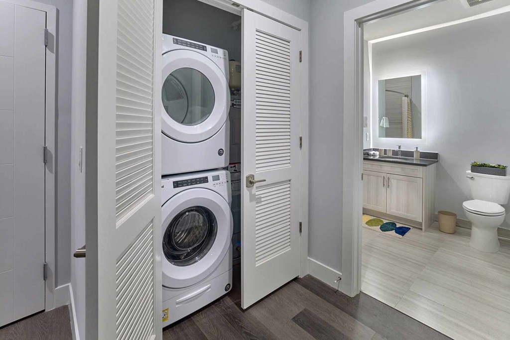 A white washing machine is in a small laundry room.