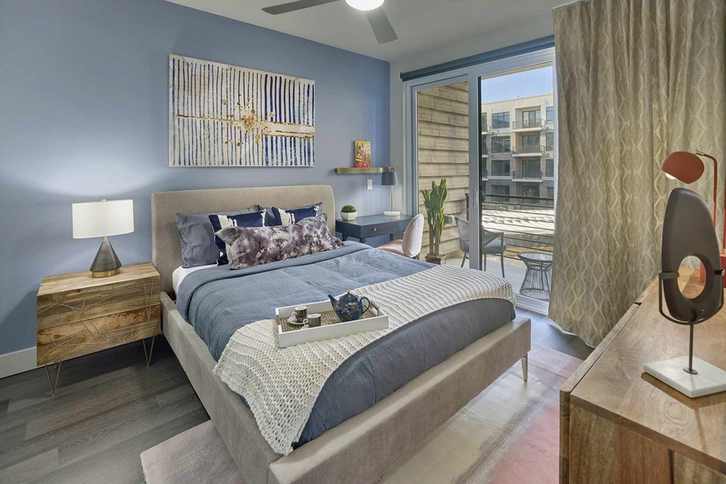 A bedroom with a large bed and a wooden nightstand.