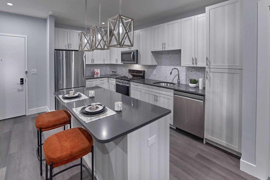 A modern kitchen with a stove top and a refrigerator.