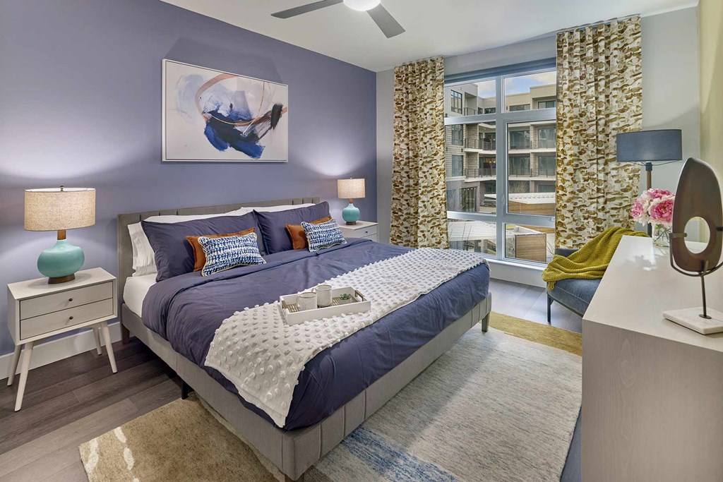 A bedroom with a large bed and a painting on the wall.