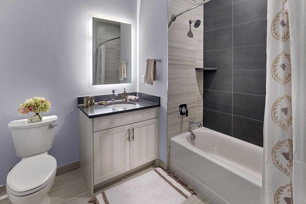 A bathroom with a white toilet, sink, and bathtub.