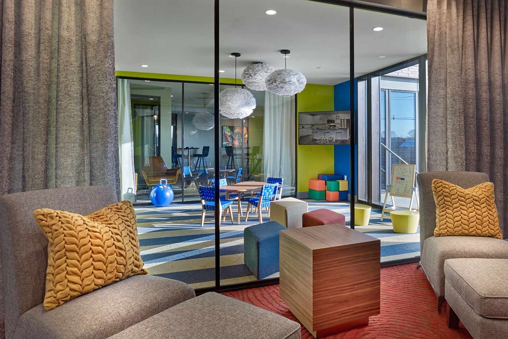 A living room with a grey couch and a yellow pillow.