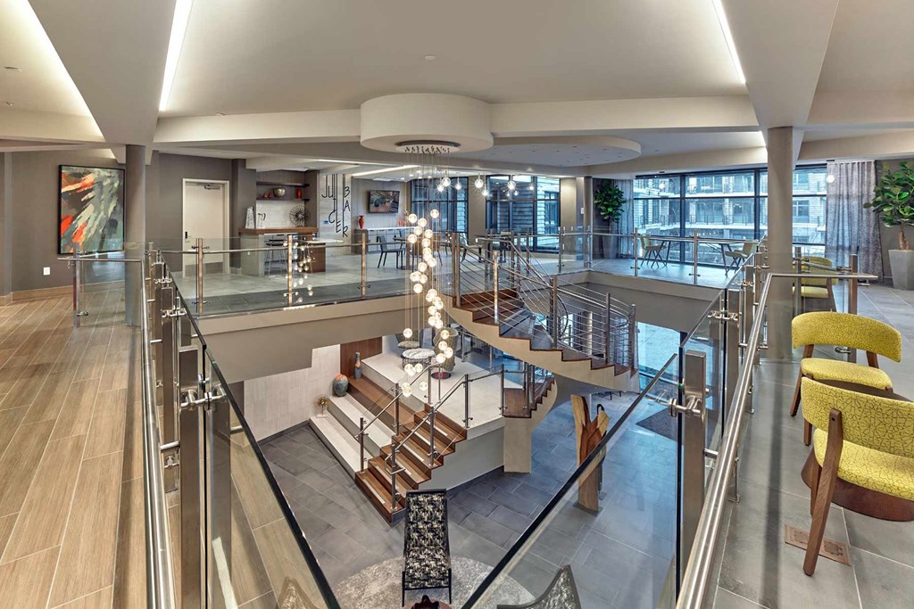 A modern interior space with a spiral staircase and a glass railing.