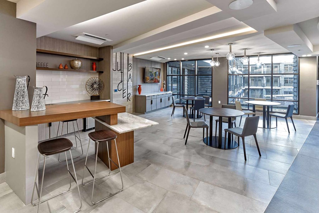 A modern kitchen with a bar area and a dining table.