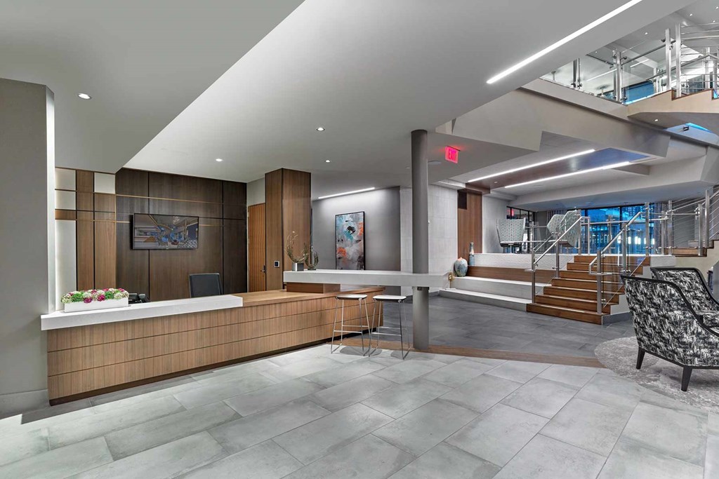 A reception area with a wooden counter and a chair.