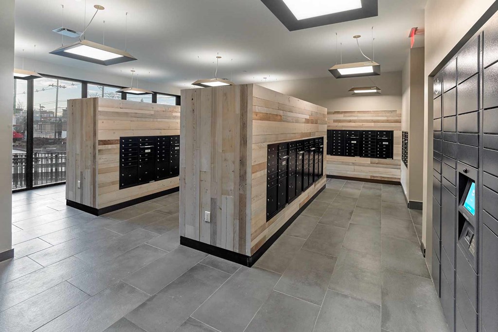 A modern office lobby with wooden panels and a digital display.