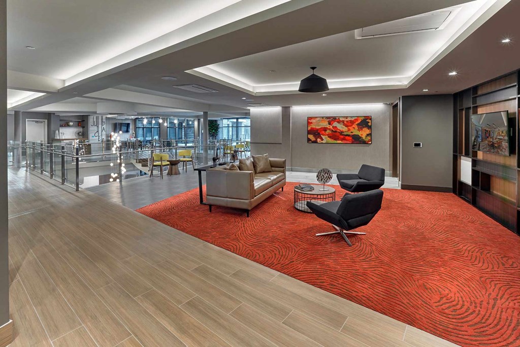 A modern office space with a red carpet and wooden flooring.