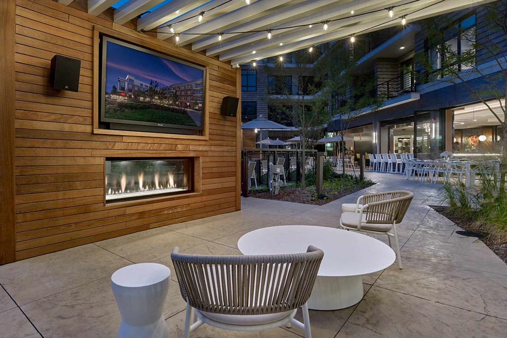 A patio with a fireplace and chairs.