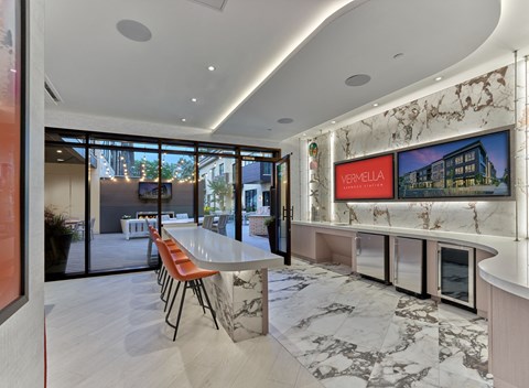the kitchen has marble countertops and a long island with chairs