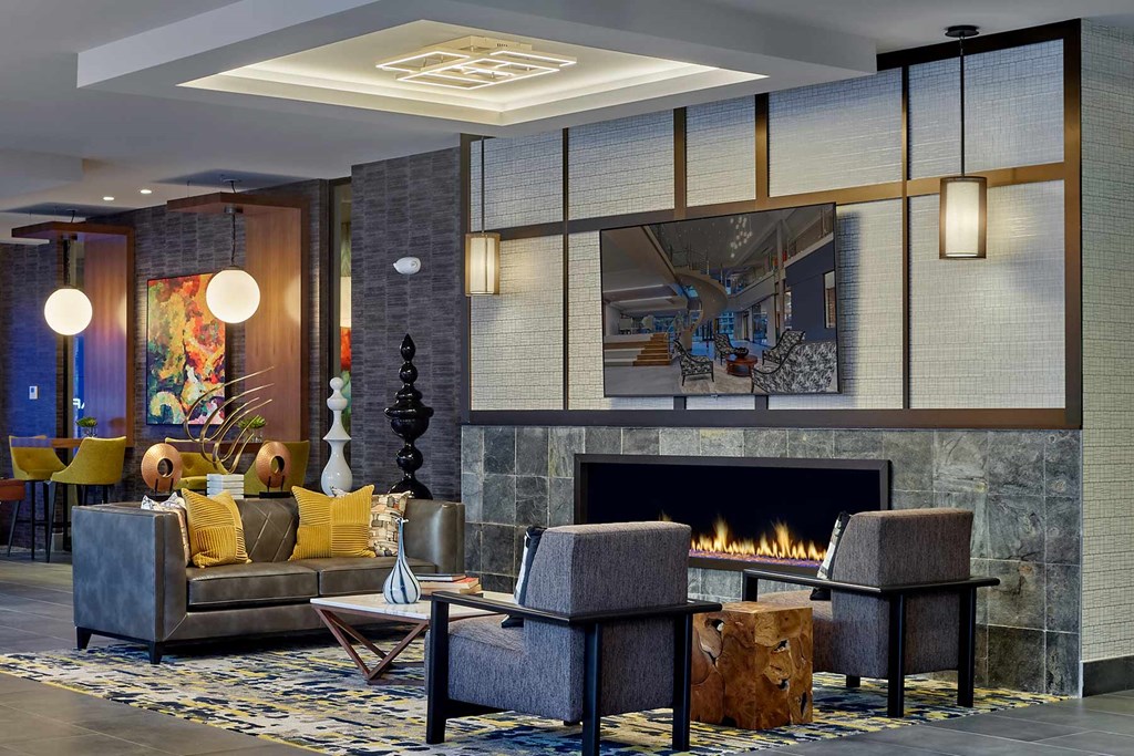 A modern living room with a fireplace and a painting on the wall.