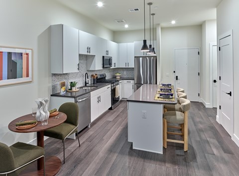 Residences A modern kitchen with a dining table and chairs.