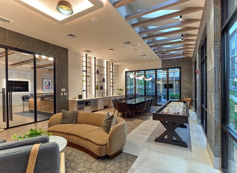 A modern living room with a pool table and a bar area.