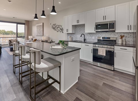 A modern kitchen with white cabinets and a large island.