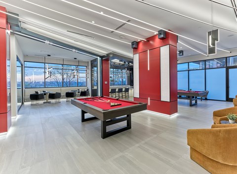 A room with a pool table and a red and white striped column.