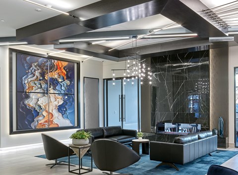 A modern living room with a large abstract painting on the wall.