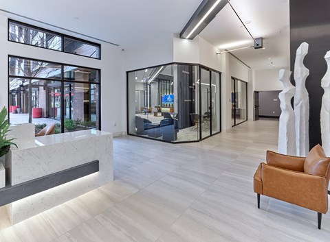 A modern office space with a reception desk, a sofa, and a large sculpture.