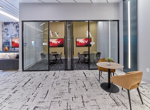 A modern office space with a glass wall and a carpet with black lines.