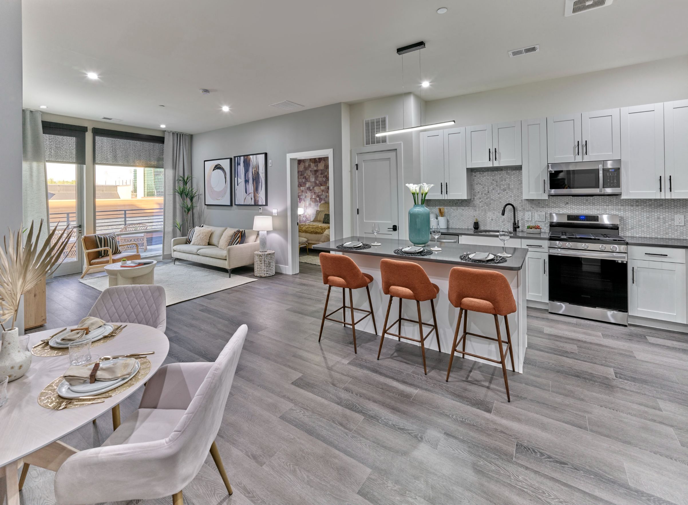 A modern kitchen with a dining table set for two.