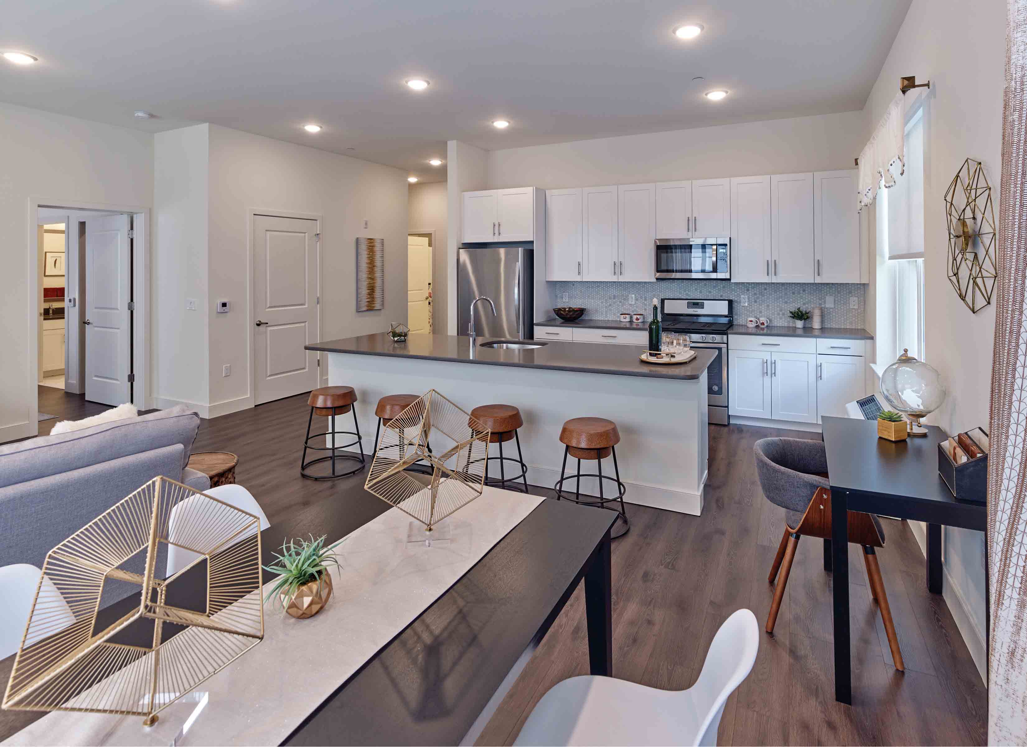 A modern kitchen with white cabinets and a black countertop.