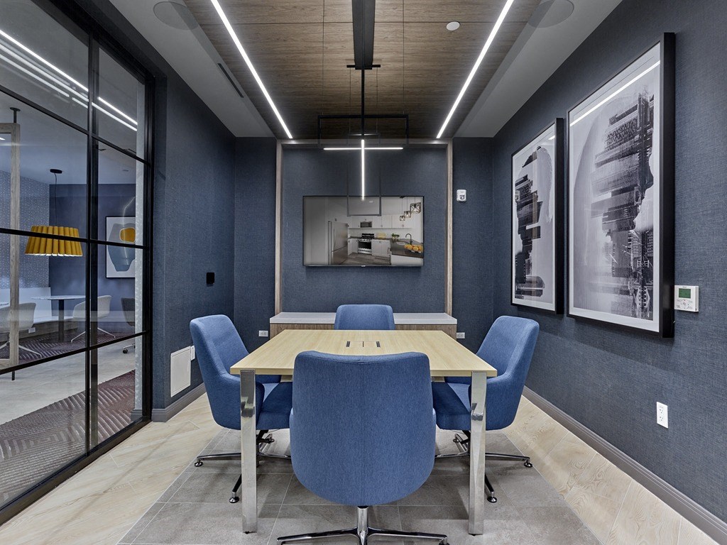 a conference room with a wooden table and blue chairs