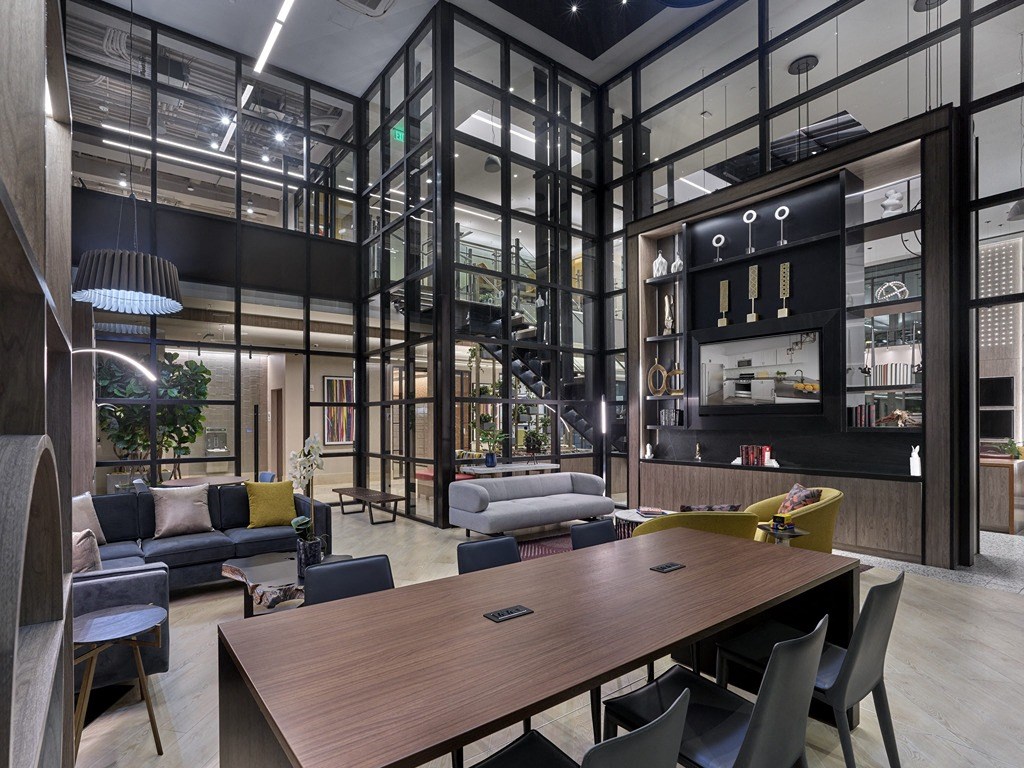 a room with a table and chairs and a lobby with glass walls