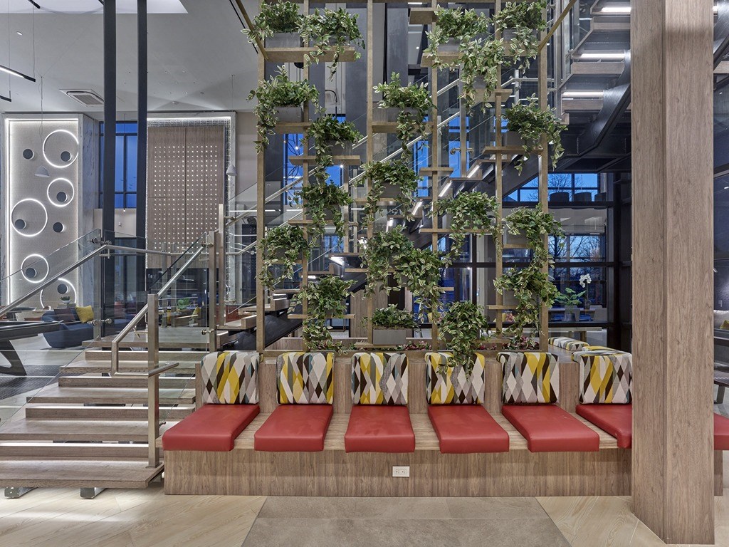 a seating area with plants and stairs in a lobby