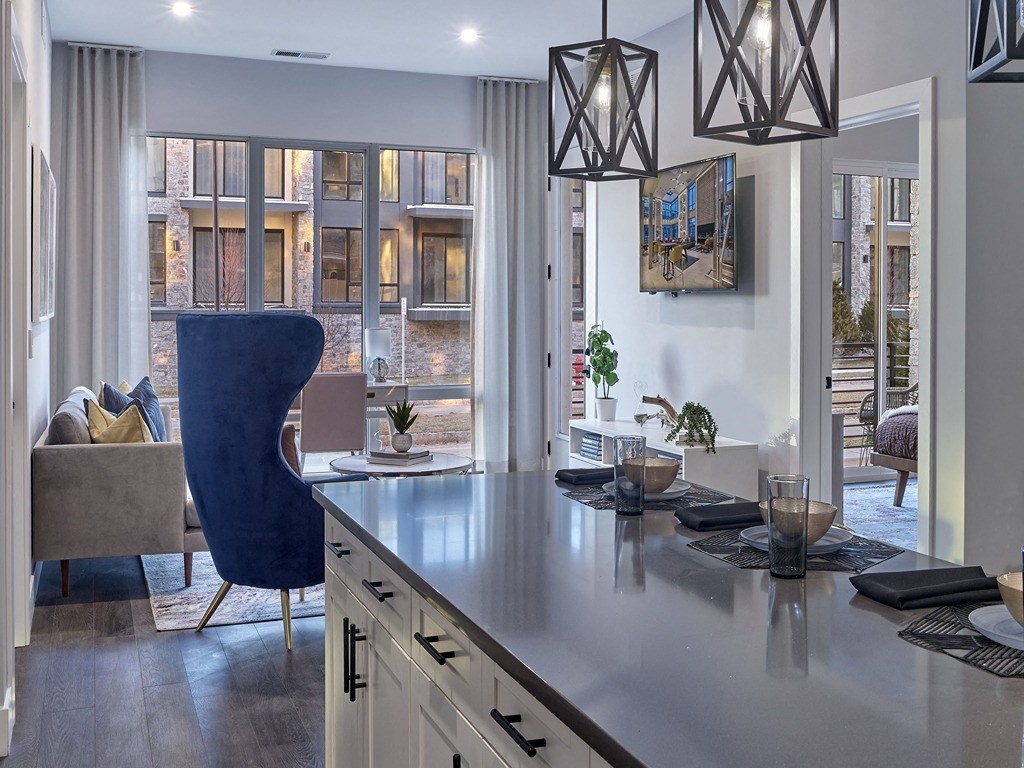 a kitchen with a counter top in front of a living room